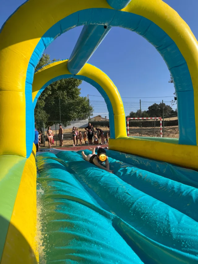 Niño deslizándose por un hinchable acuático en las fiestas de Casas de Belvís